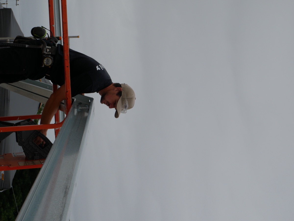 AGATHĒ builder installing a wall panel on site