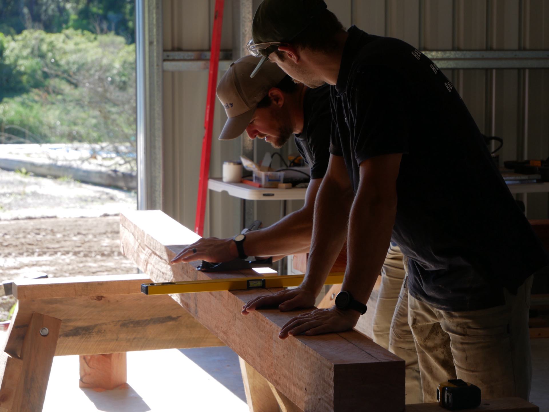 AGATHĒ builder working timber at the bench