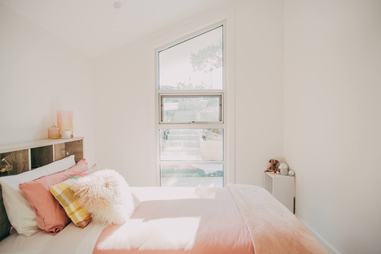 Bedroom with a large window and natural light in the Castle Hill home