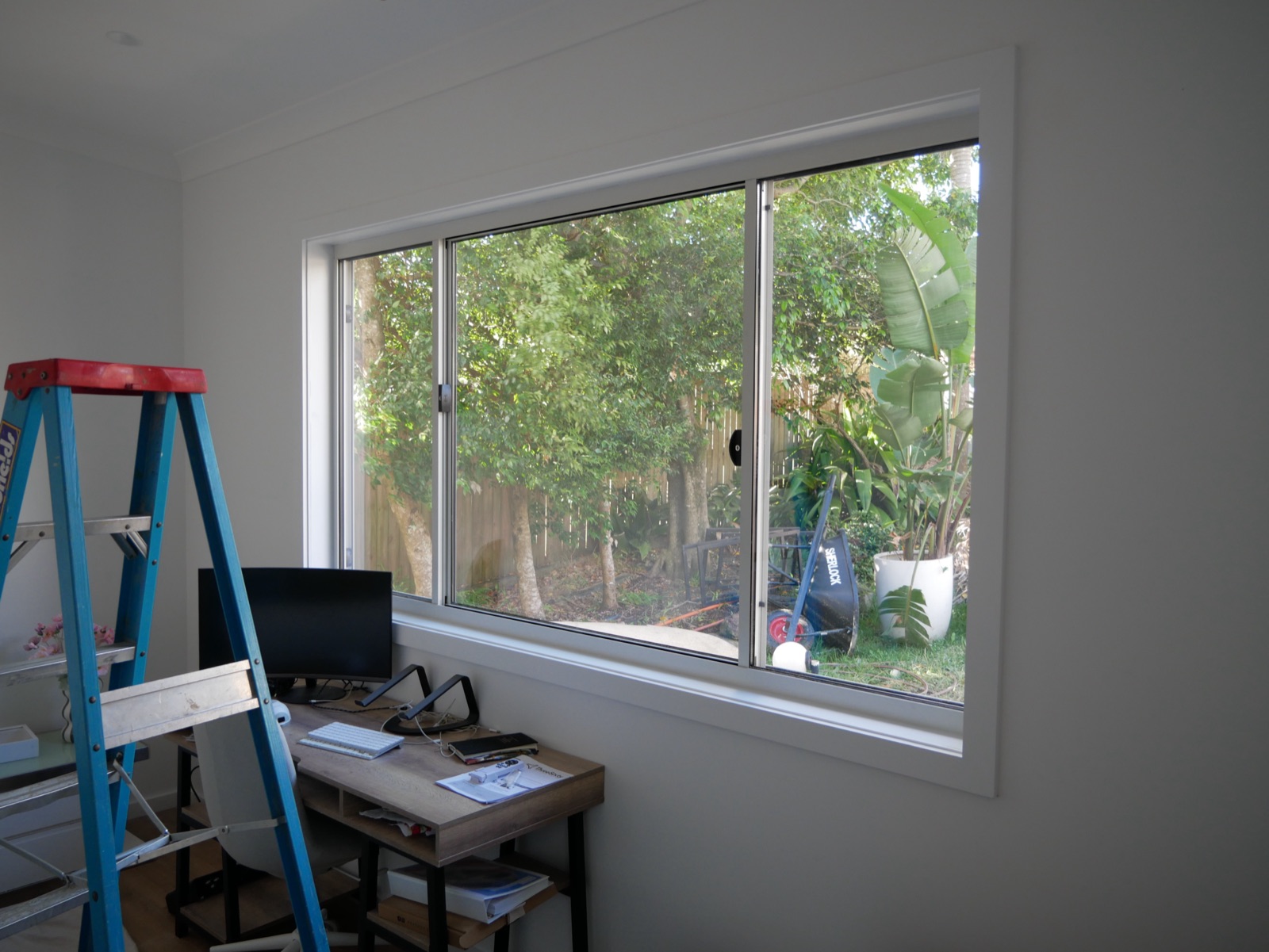 White barn doors on a brass track in the renovated Frenchs Forest hallway with a timber door and skylight