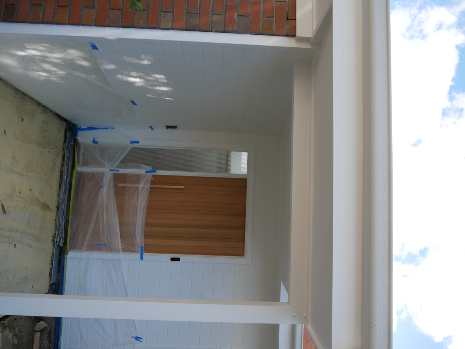 The new entry portico of the Frenchs Forest home with white posts and a timber front door