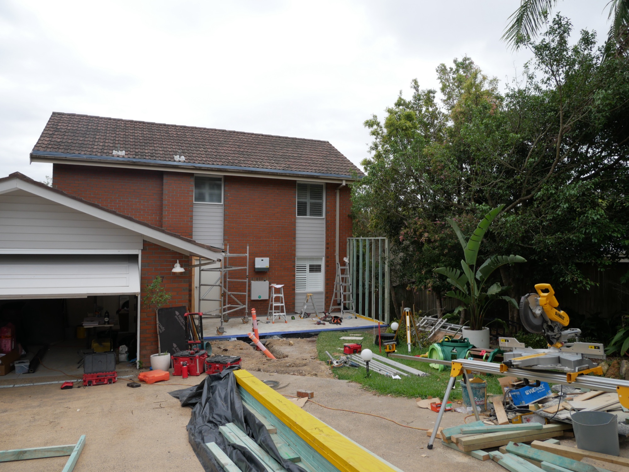 The original two-storey brick home in Frenchs Forest with the first framing of the new front extension underway