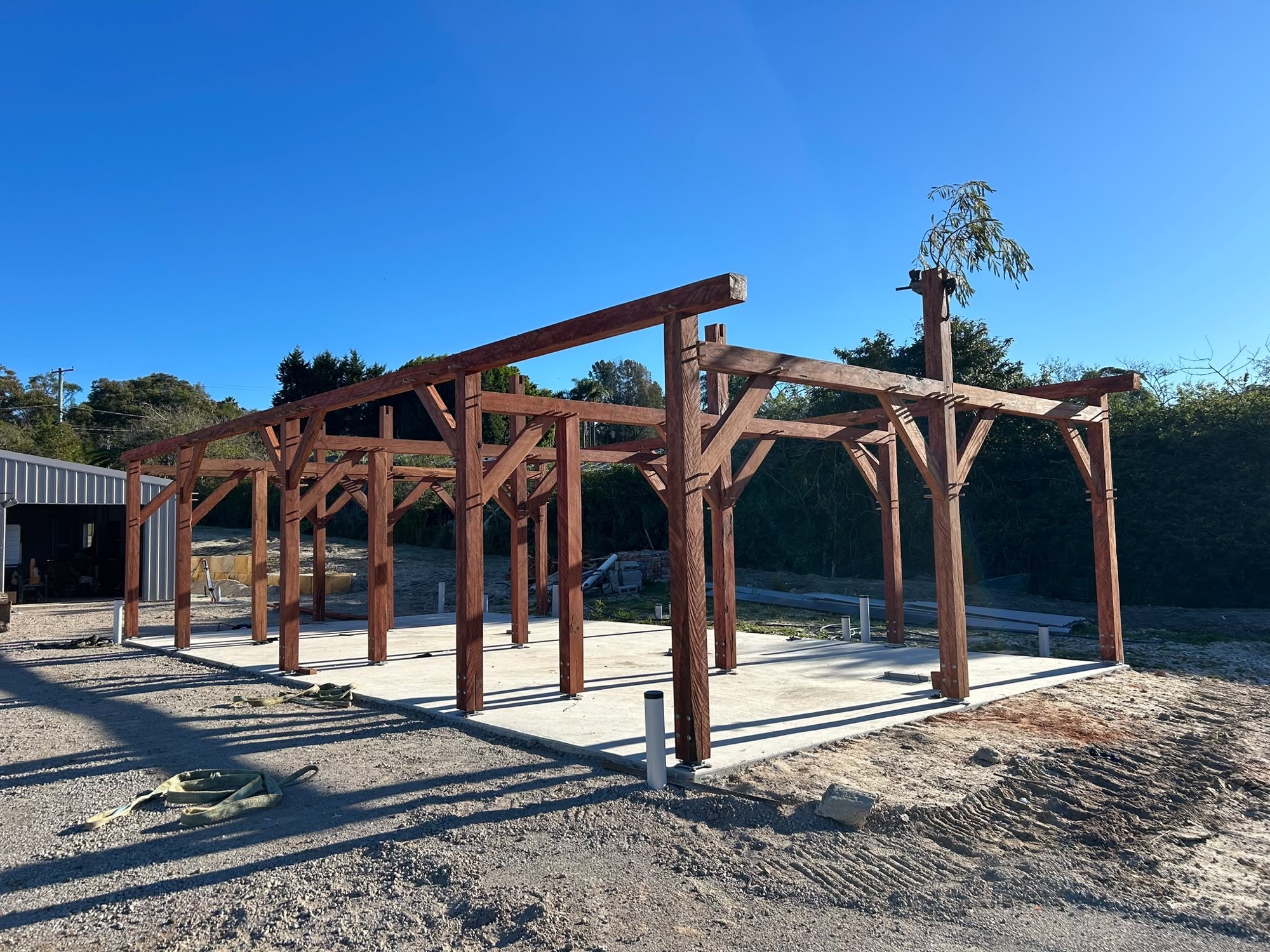 Custom hardwood post-and-beam stable frame standing on its concrete slab at the Ingleside property