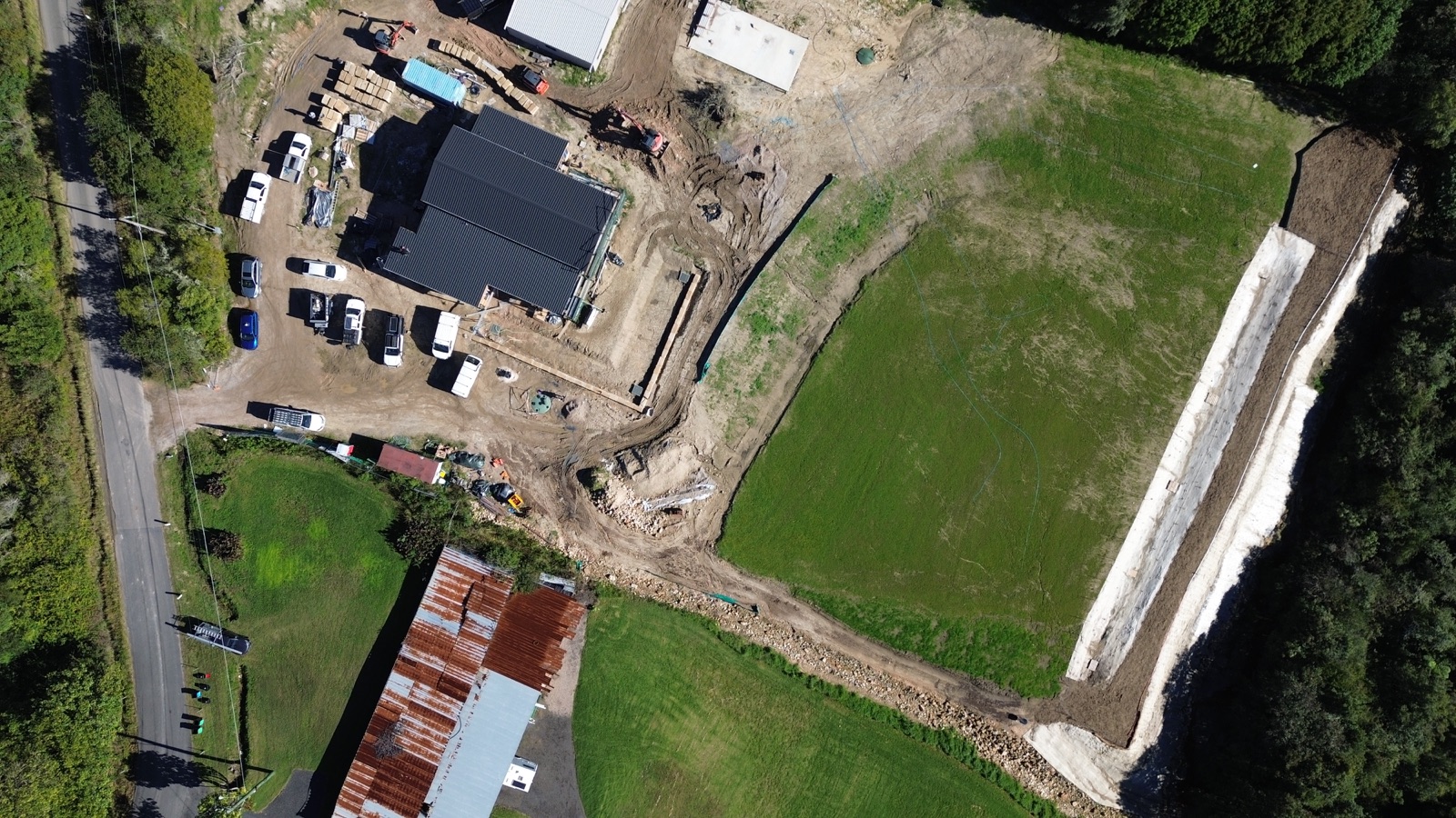 Aerial view of the Ingleside site with new turf and landscaping around the dark-roofed home