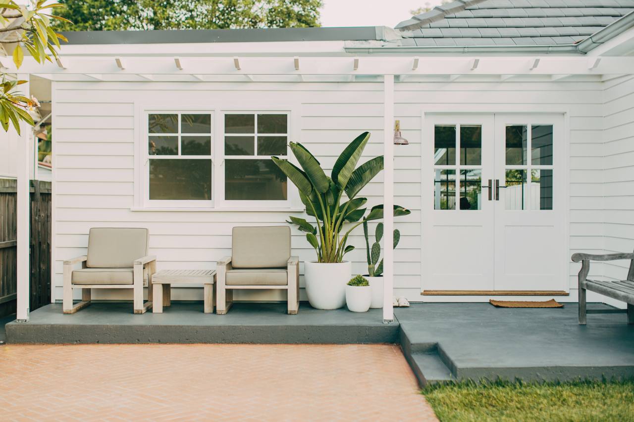 Rear timber deck with a pergola and outdoor lounge seating at the North Narrabeen home