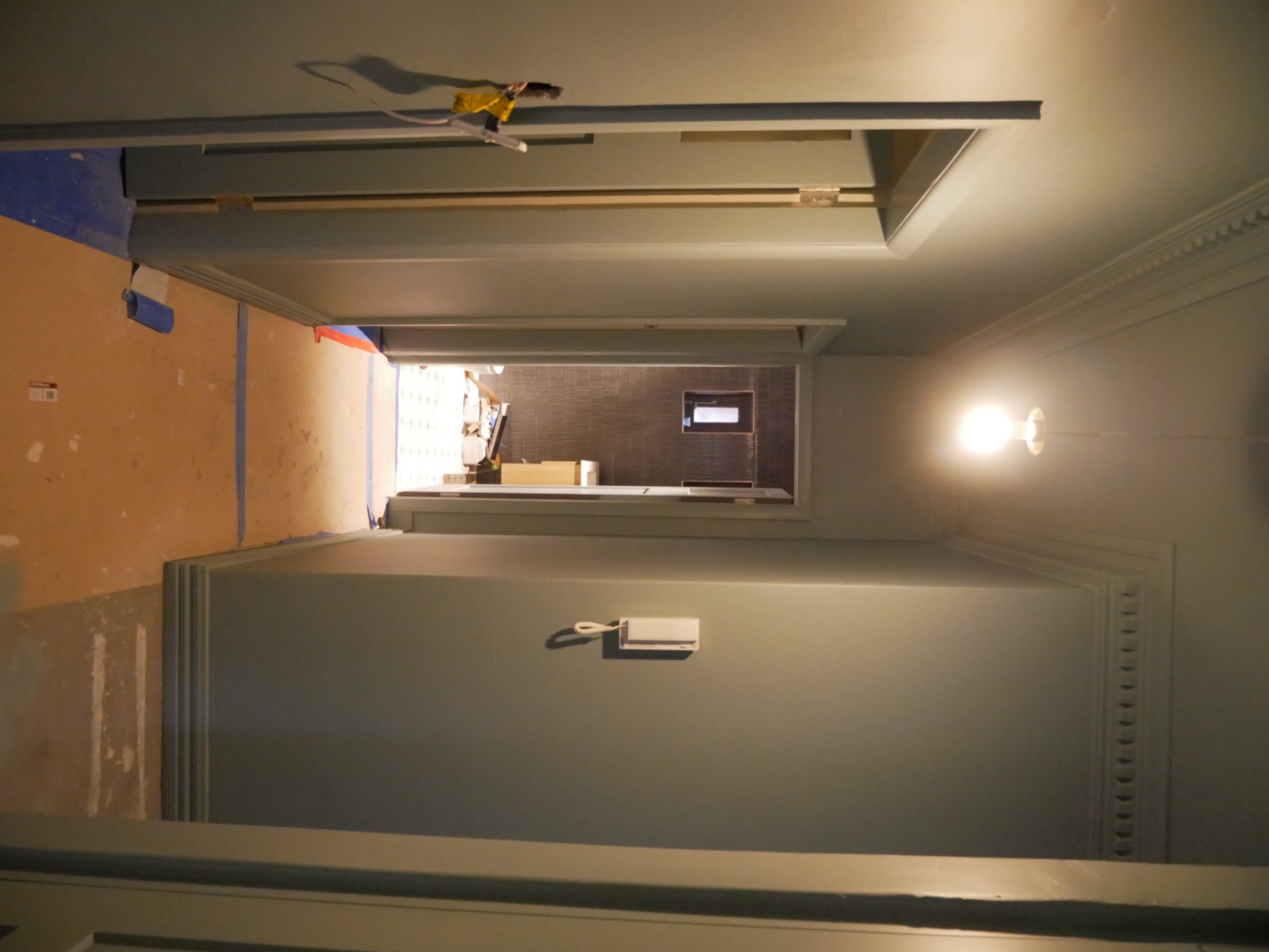The Neutral Bay apartment hallway freshly painted with its period cornice and pendant light