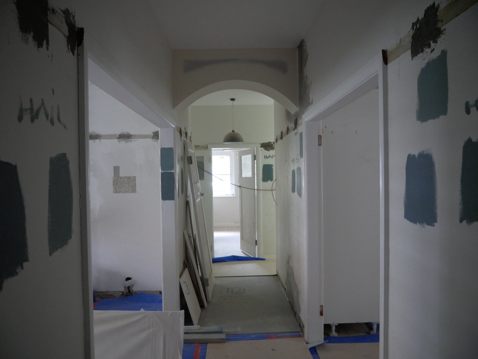Period archway in the Neutral Bay apartment hallway with paint colours being tested on the walls