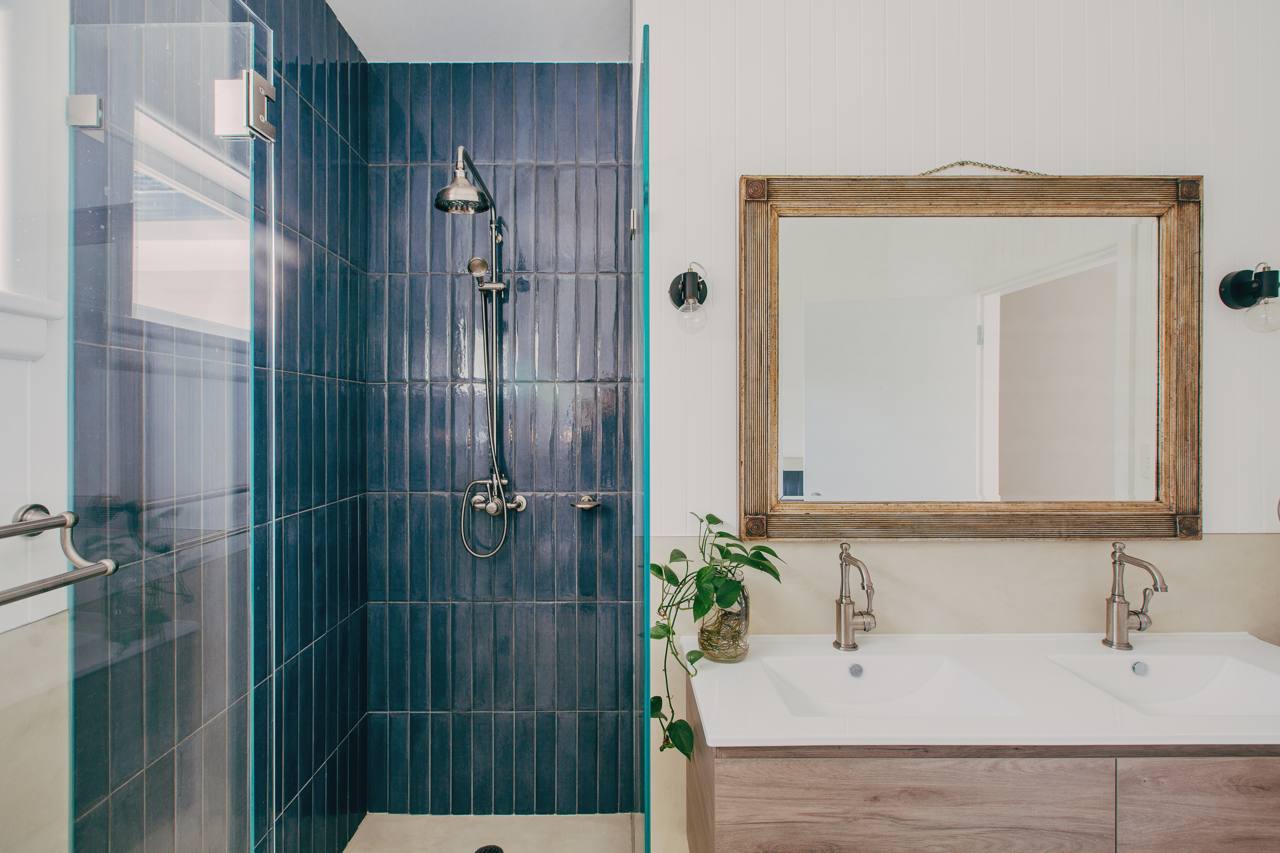 Second bathroom with teal tiling, a timber-framed mirror and micro-cement vanity in the Pymble home