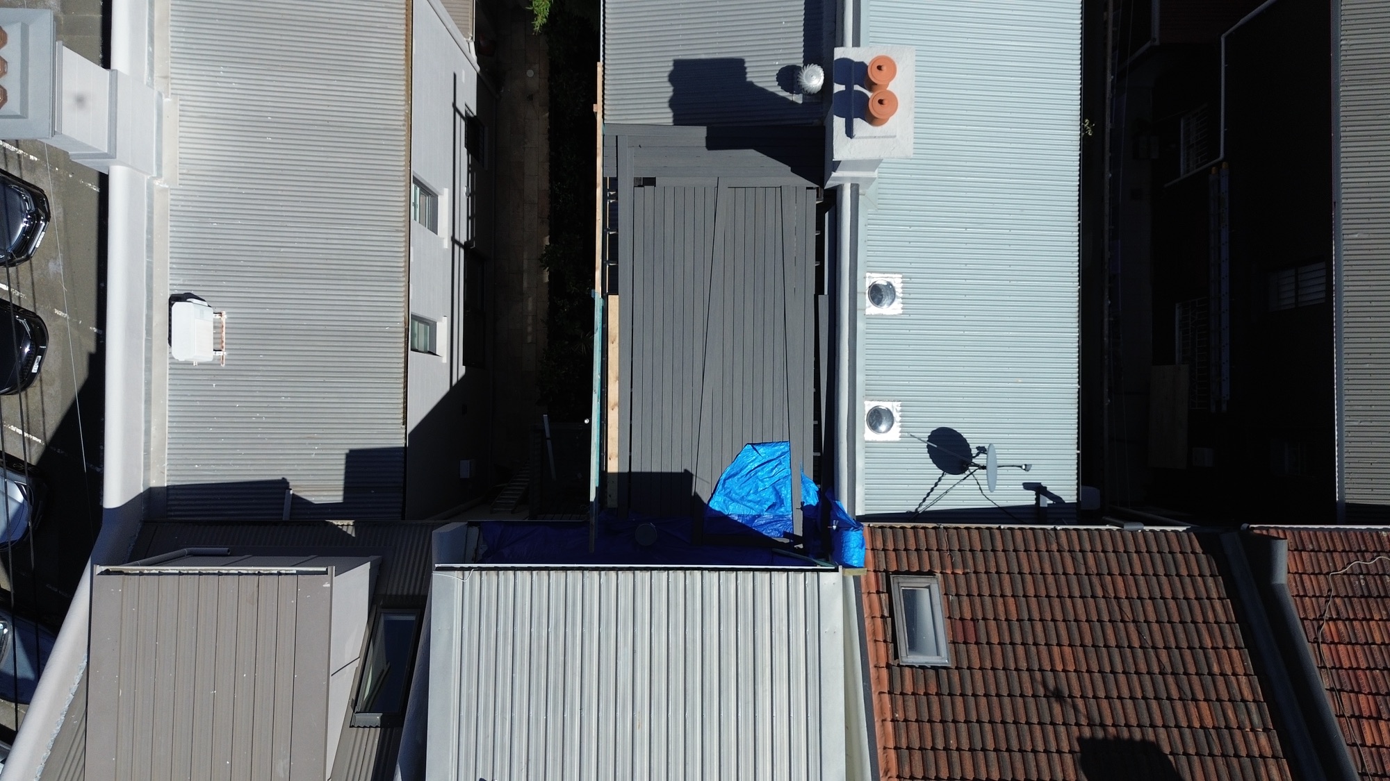 Aerial view of the Redfern terrace renovation within its row of terrace rooftops, AGATHĒ Builders